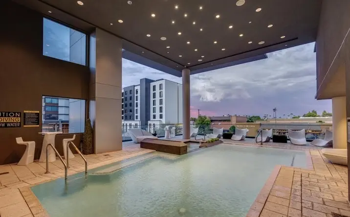 Heated pool deck at dusk overlooking Old Town Scottsdale at Envy Residences